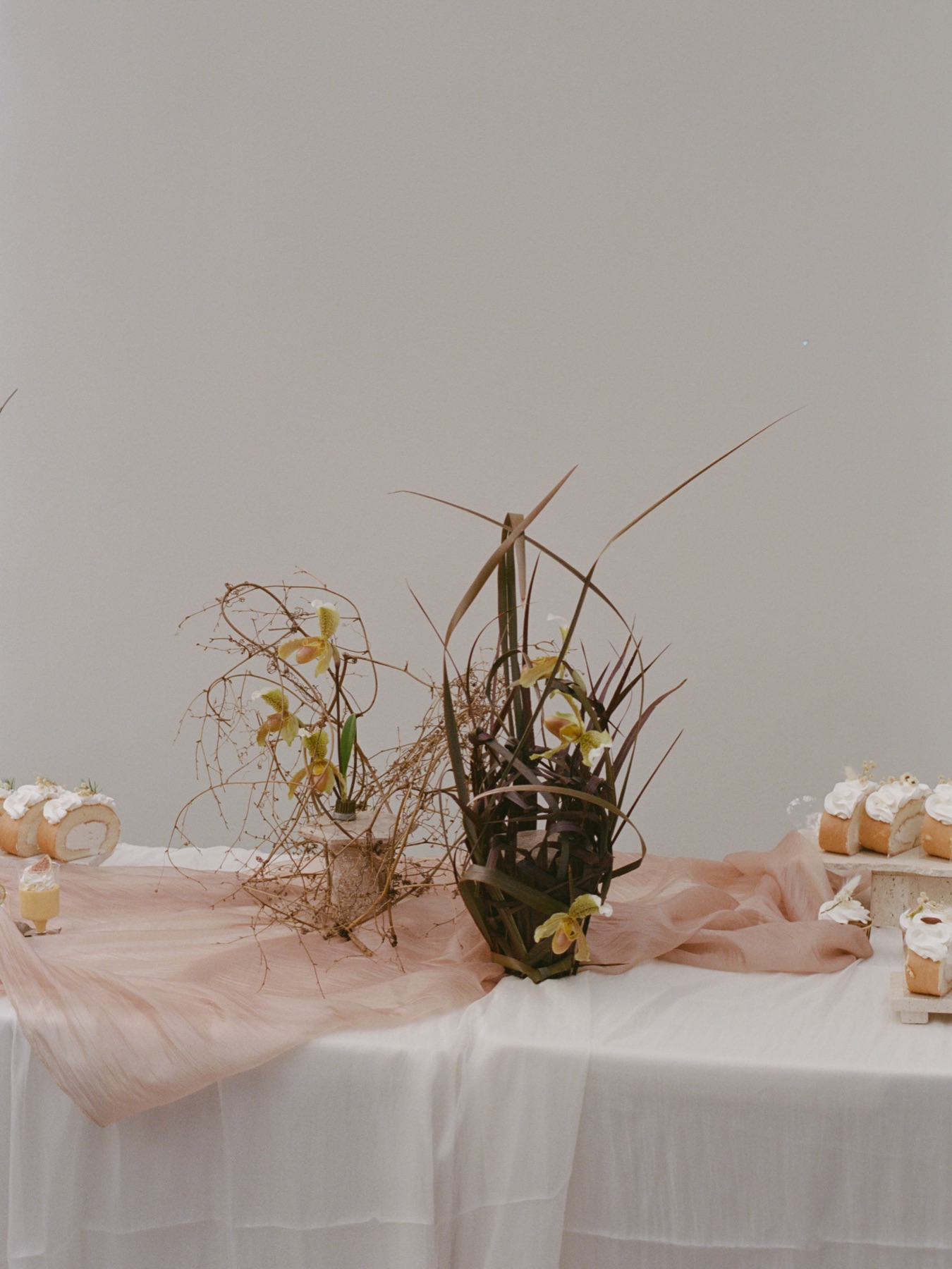 A floral installation with pale yellow orchids emerging through dark foliage.