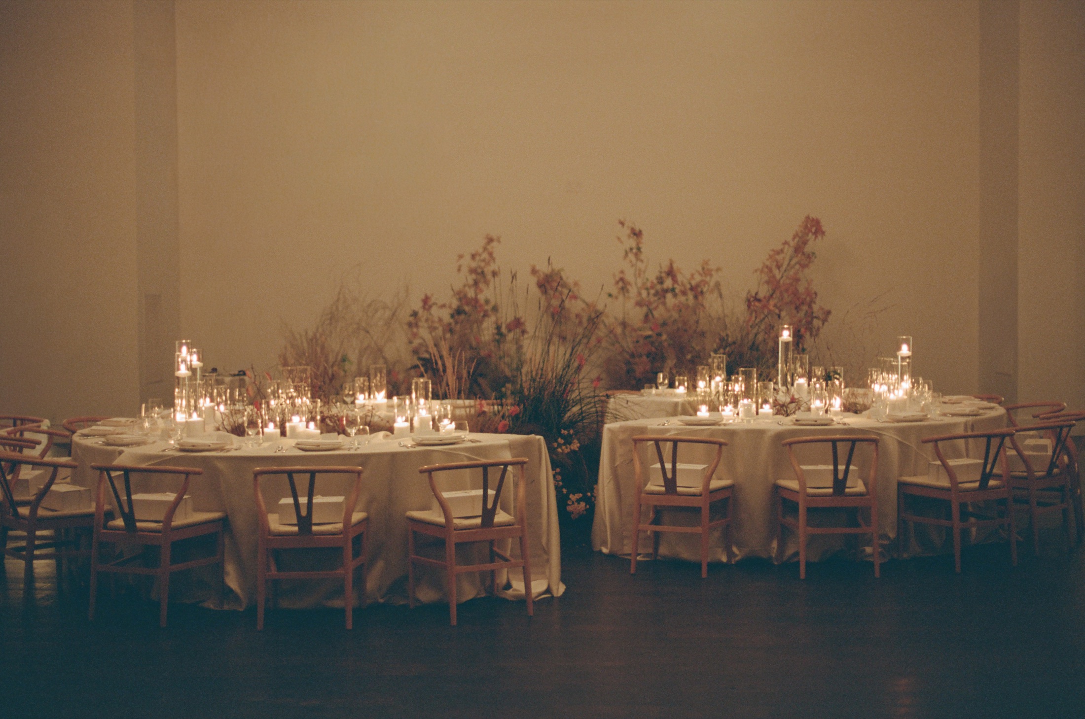 Golden candlelit wedding dinner with warm neutral details.